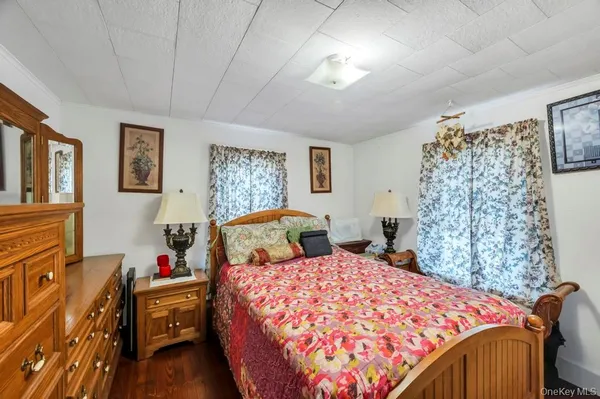 a bed sitting in a bedroom next to a window and a chandelier