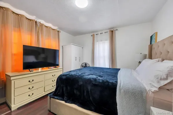 a bedroom with a bed and a flat screen tv