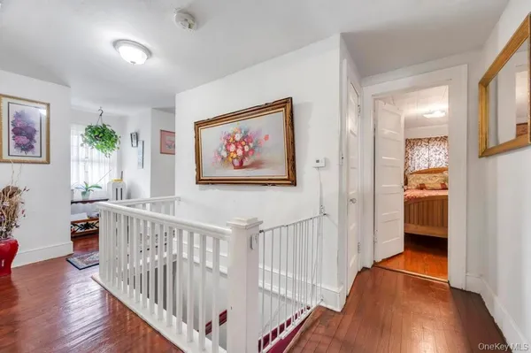 a view of a hallway with wooden floor and furniture