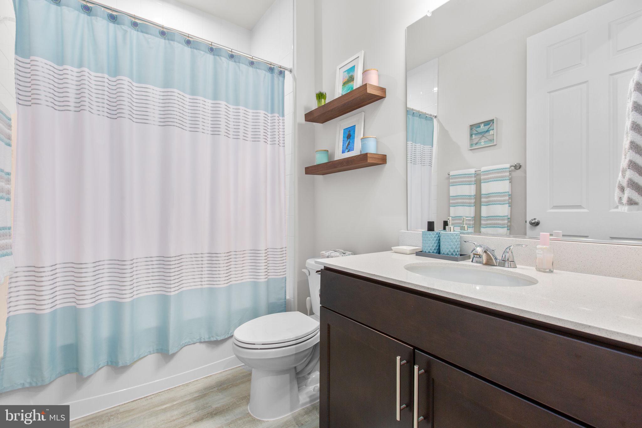 6306 Bobcat Lane King George, VA 22485 - Photo 33 of 58 a bathroom with a sink a toilet and shower curtain