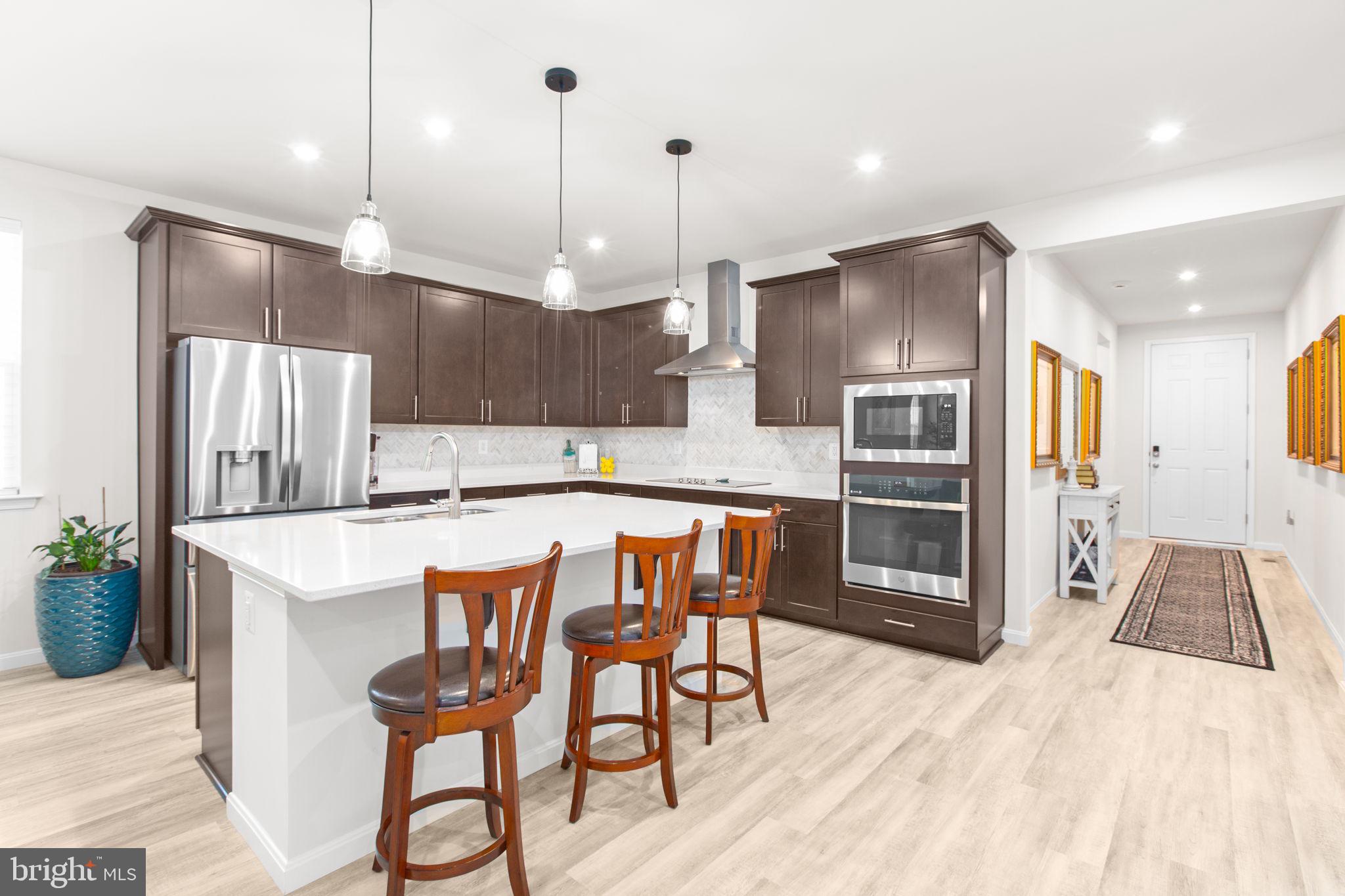 6306 Bobcat Lane King George, VA 22485 - Photo 4 of 58 a kitchen with stainless steel appliances kitchen island a refrigerator and a stove top oven