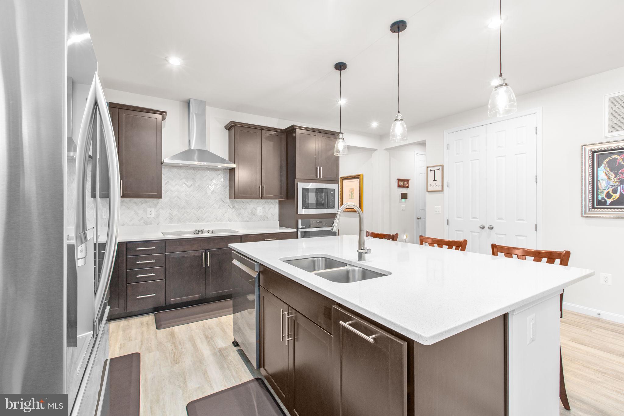6306 Bobcat Lane King George, VA 22485 - Photo 5 of 58 a kitchen that has a sink a center island stainless steel appliances and cabinets