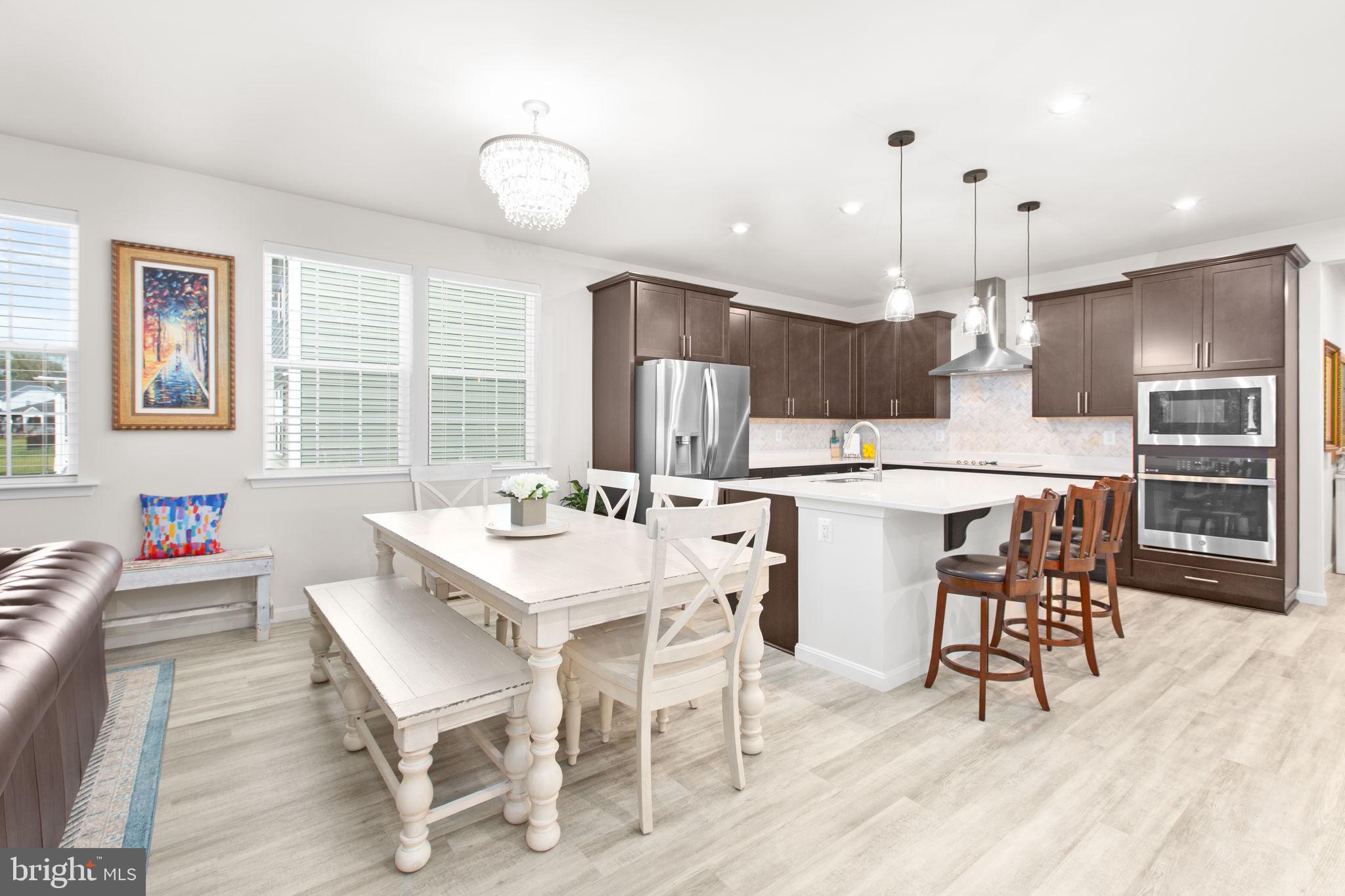 6306 Bobcat Lane King George, VA 22485 - Photo 9 of 58 a kitchen with stainless steel appliances kitchen island granite countertop a dining table chairs and white cabinets