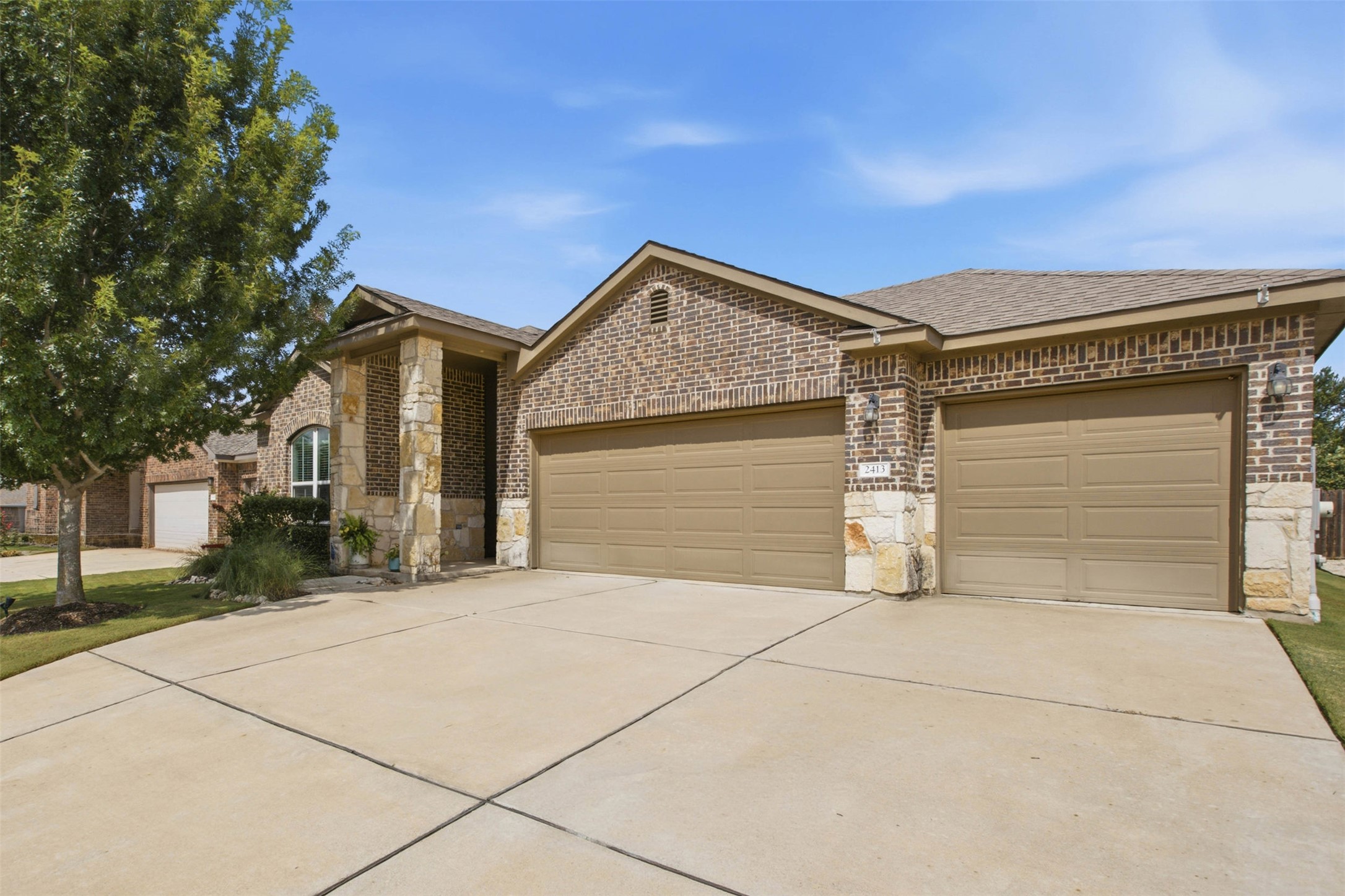 2413 Bridges Ranch Road Georgetown, TX 78628 - Photo 4 of 31 A classic brick and stone facade welcomes with a broad driveway and integrated garage access.