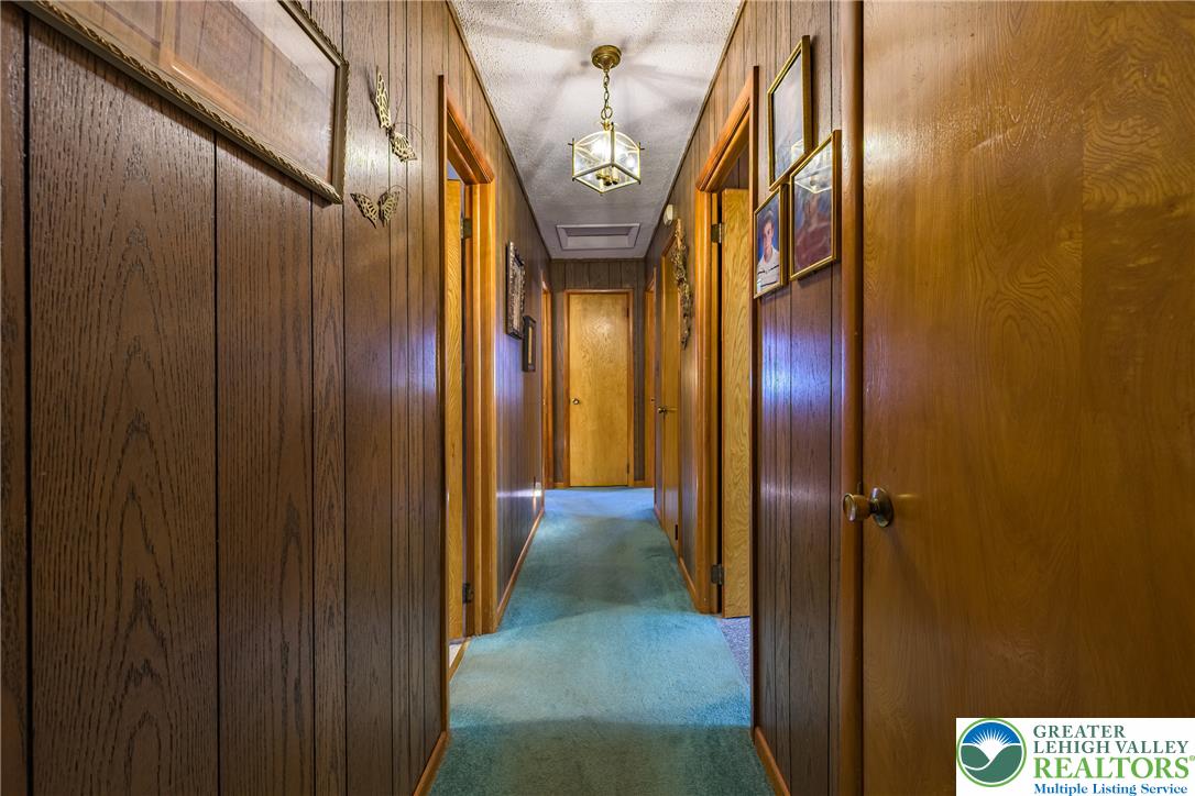 678 Interchange Road Kresgeville, PA 18333 - Photo 28 of 45 A well-lit hallway with paneling and a striking brass light fixture.