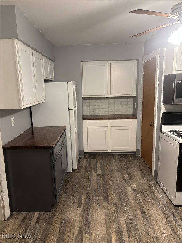 1019 Quilliams Road Cleveland Heights, OH 44121 - Photo 12 of 32 Kitchen with white appliances, dark wood-style floors, tasteful backsplash, dual tone cabinets, and wooden counters