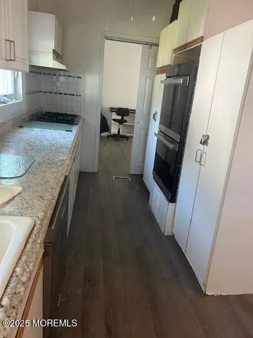 a bathroom with a granite countertop toilet a mirror and a sink