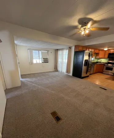 a view of a livingroom with a ceiling fan and window