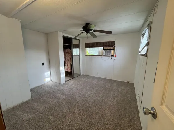 a view of a livingroom with a ceiling fan & entryway