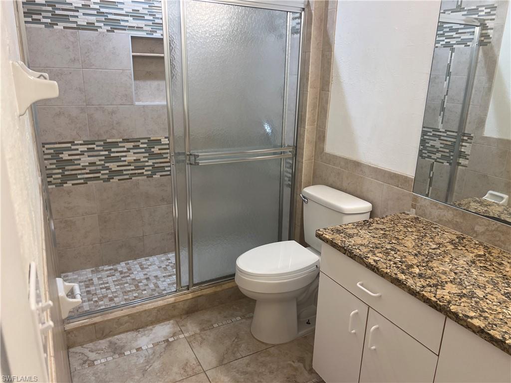 3841 Schoolhouse Road East, Unit 7 Fort Myers, FL 33916 - Photo 11 of 24 a bathroom with a granite countertop toilet and a shower