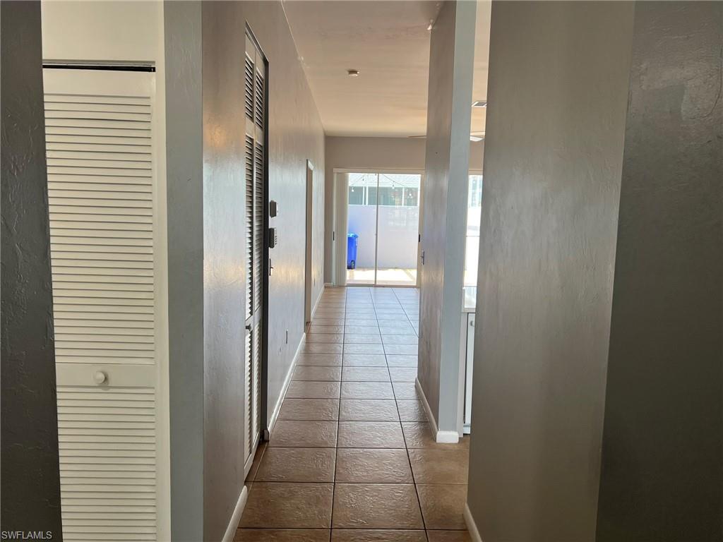3841 Schoolhouse Road East, Unit 7 Fort Myers, FL 33916 - Photo 13 of 24 a view of a hallway with wooden floor and a bathroom
