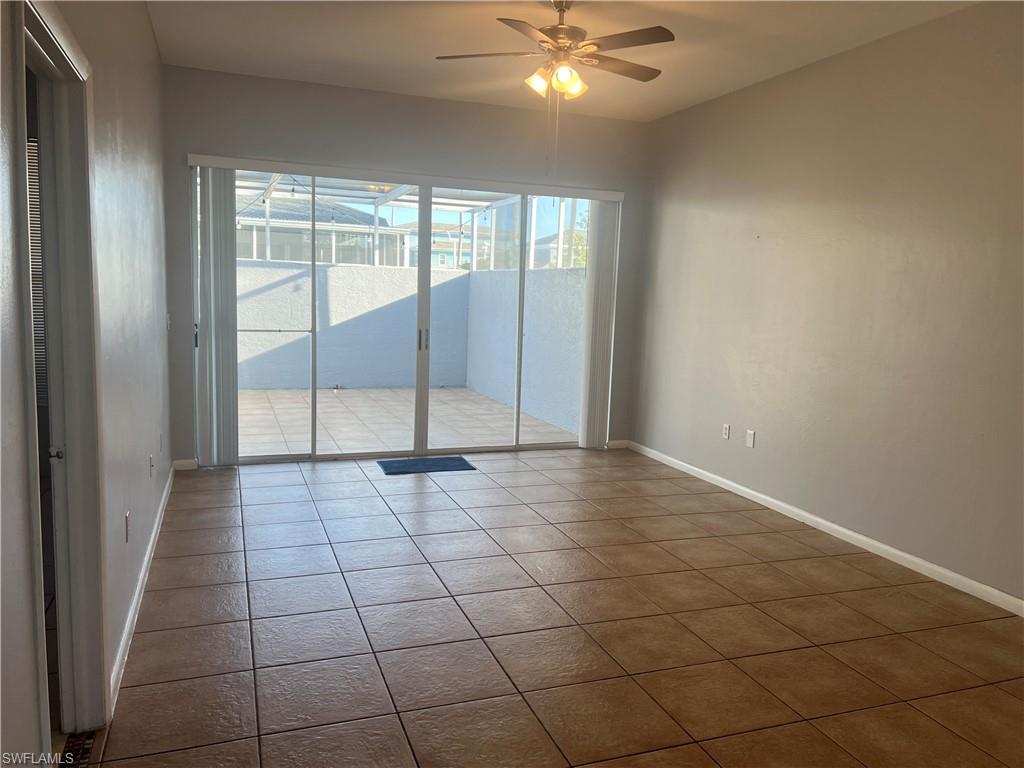 3841 Schoolhouse Road East, Unit 7 Fort Myers, FL 33916 - Photo 6 of 24 en empty room with windows and chandelier fan