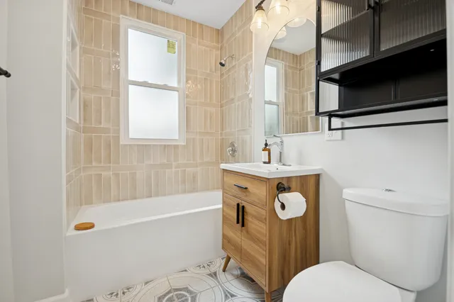 a bathroom with a sink a toilet a mirror and shower