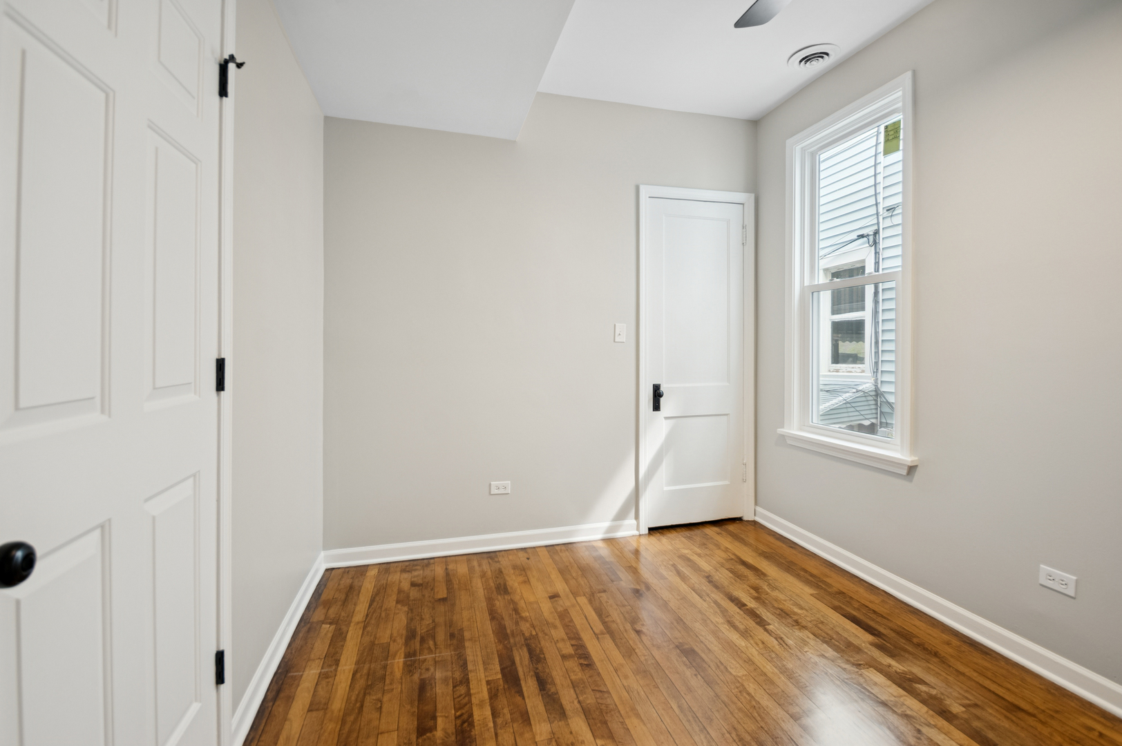 3300 North Karlov Avenue, Unit 1 Chicago, IL 60641 - Photo 14 of 17 a view of empty room with wooden floor and fan