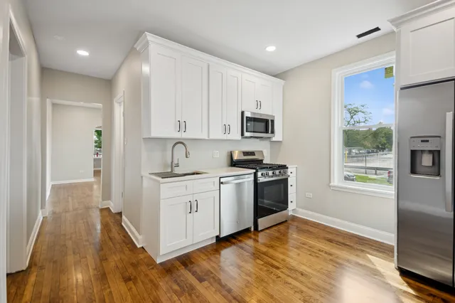 a kitchen with stainless steel appliances granite countertop a stove a sink and a refrigerator