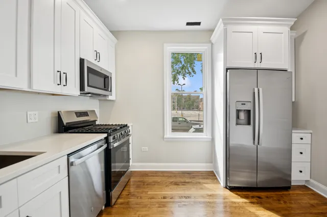 a kitchen with stainless steel appliances granite countertop a refrigerator sink and stove