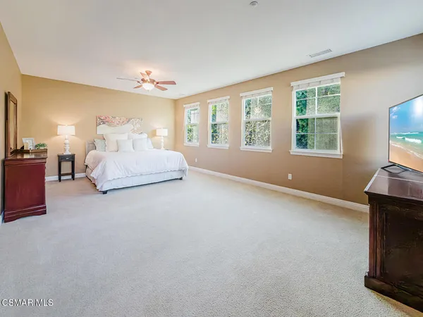 a view of a bedroom with workspace and wooden floor