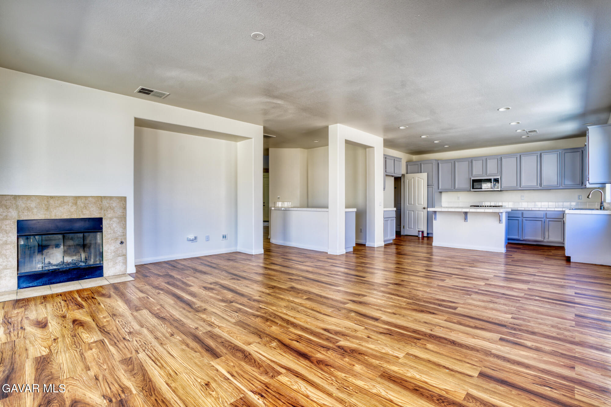 37928 Pisces Circle Palmdale, CA 93552 - Photo 5 of 32 a view of kitchen and kitchen with furniture wooden floor and a fireplace