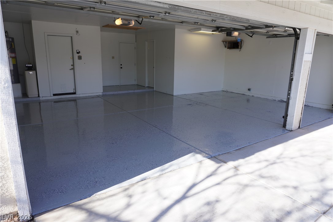 8328 Del Rey Avenue Las Vegas, NV 89117 - Photo 5 of 38 A spotless, newly finished garage with a gleaming epoxy floor, ready for vehicles or projects.