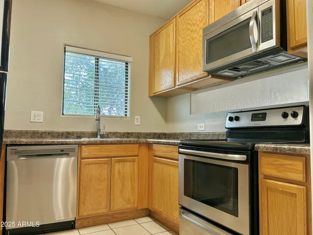 a kitchen with stainless steel appliances granite countertop a stove microwave and cabinets
