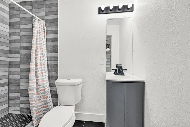 a bathroom with a toilet a sink and mirror