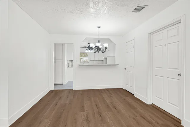 a view of a room with wooden floor and chandelier