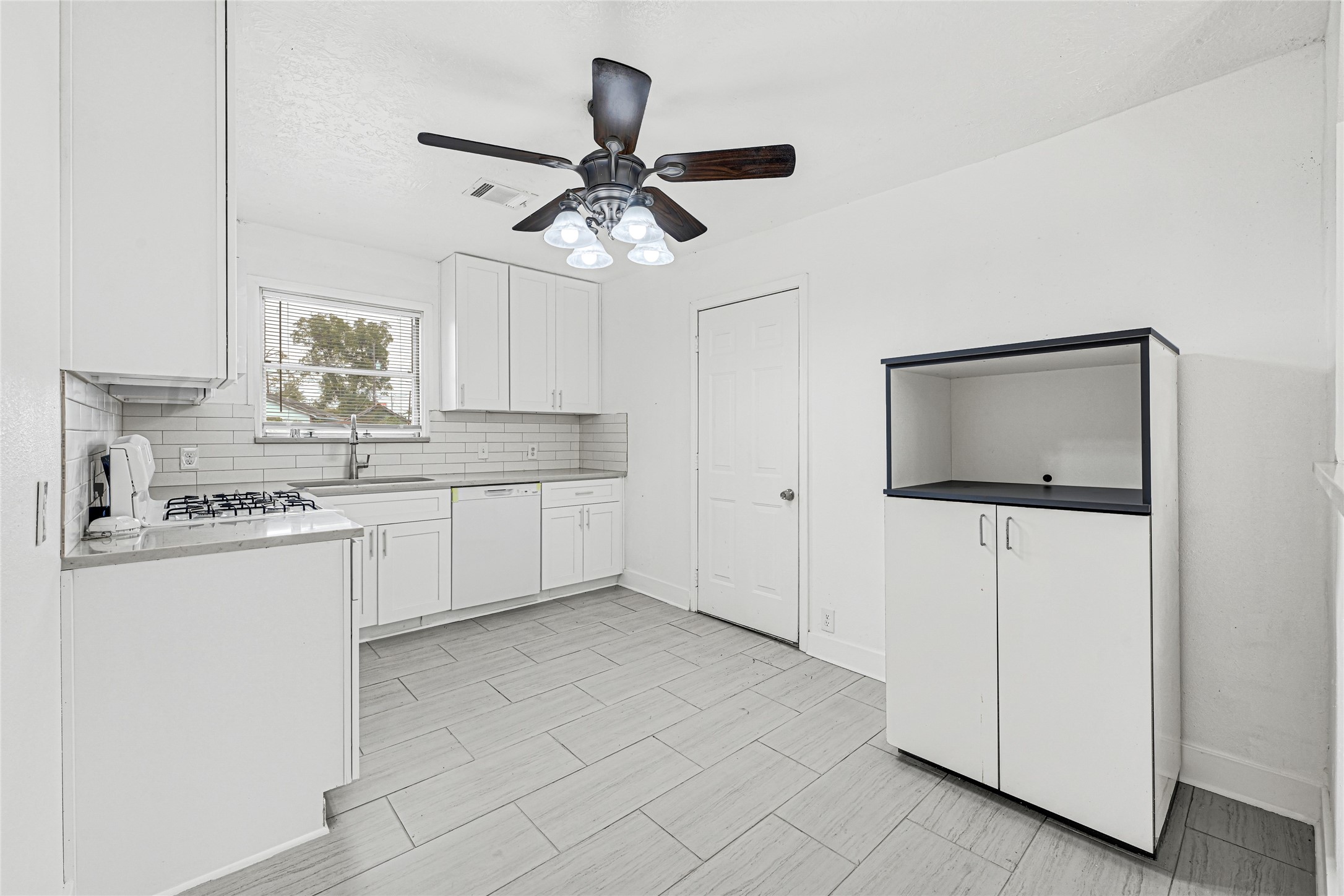 4215 East Lane Houston, TX 77026 - Photo 19 of 25 a kitchen with kitchen island white cabinets appliances and a counter top space