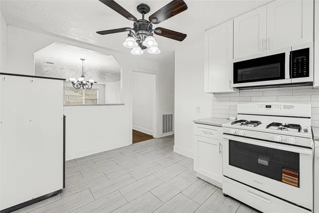 a kitchen with stainless steel appliances a stove microwave and cabinets