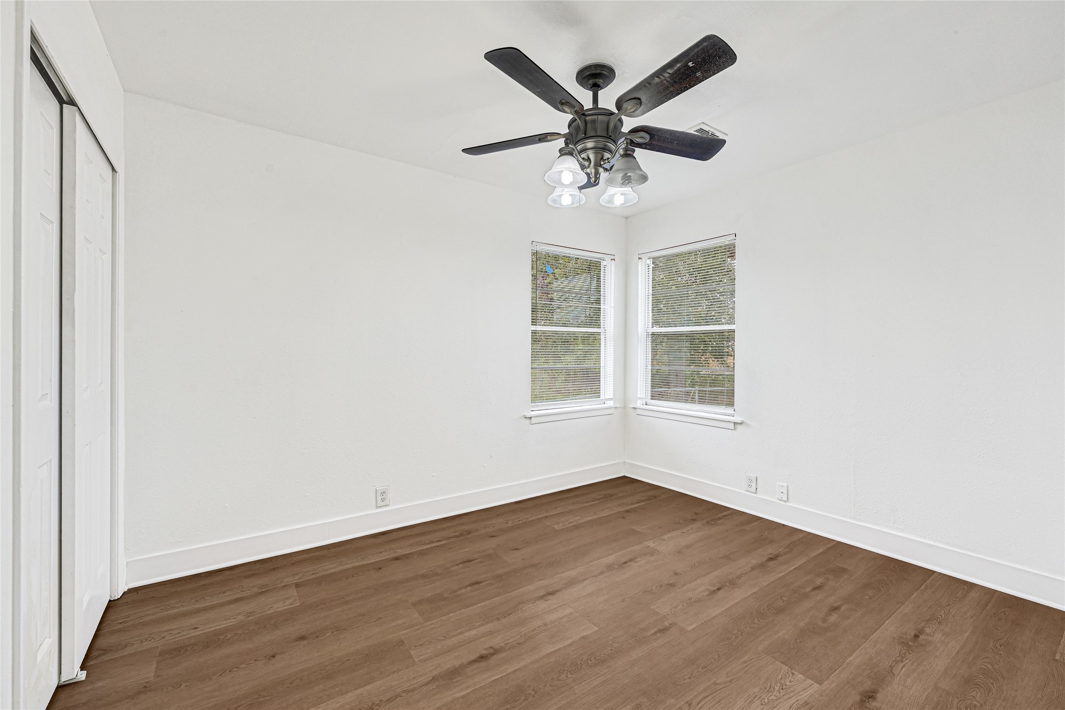 4215 East Lane Houston, TX 77026 - Photo 22 of 25 an empty room with wooden floor chandelier fan and windows