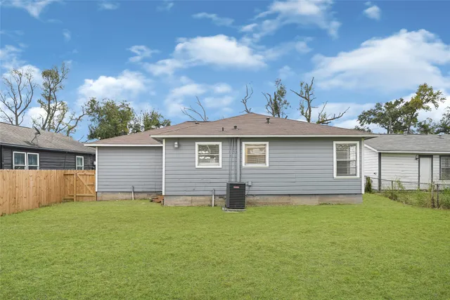 a front view of house with yard and trees in the background