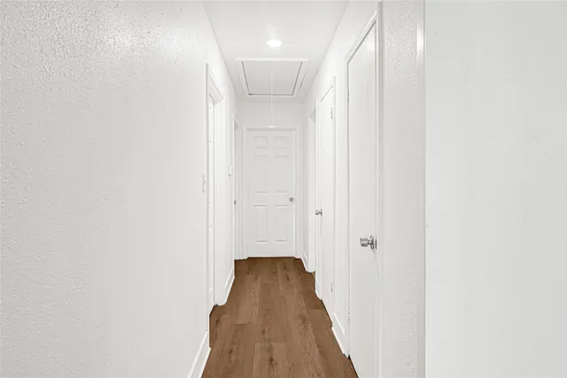 a view of a hallway with wooden floor