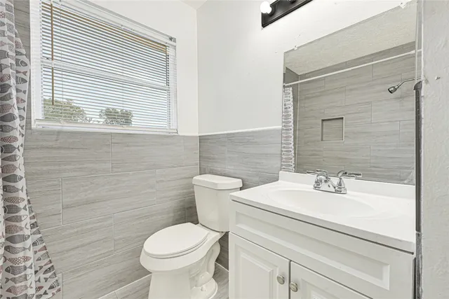 a bathroom with a sink toilet and a mirror