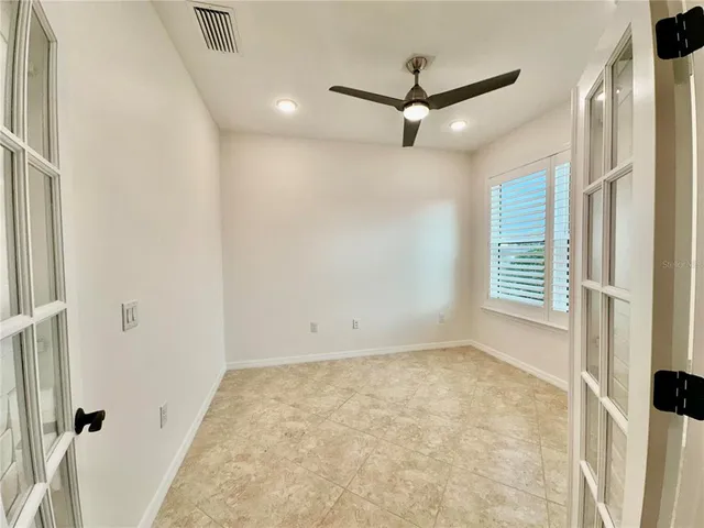 a kitchen with granite countertop a table chairs microwave and refrigerator