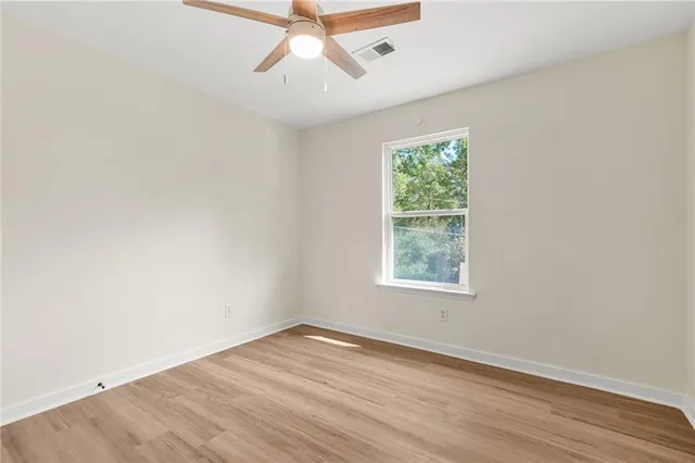 an empty room with a window and wooden floor