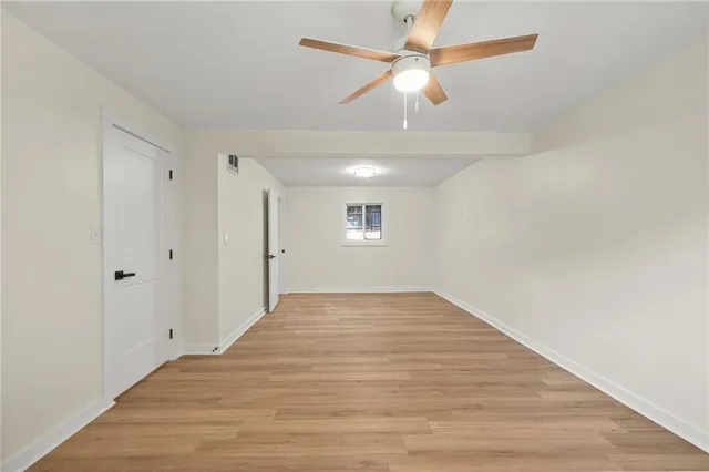 a view of an empty room and chandelier fan