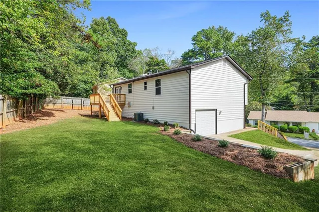 a view of a backyard with plants and a large tree