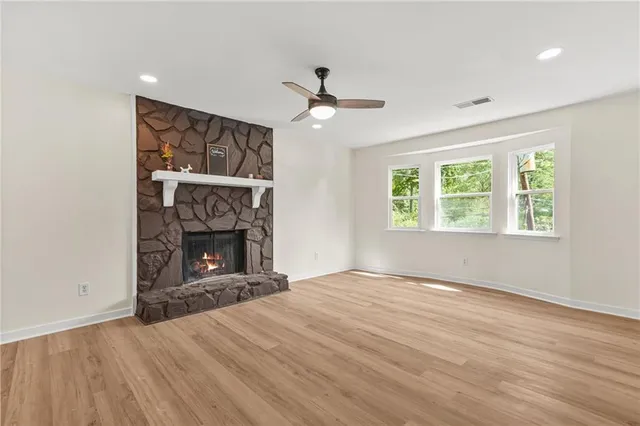 an empty room with windows fireplace and a sink