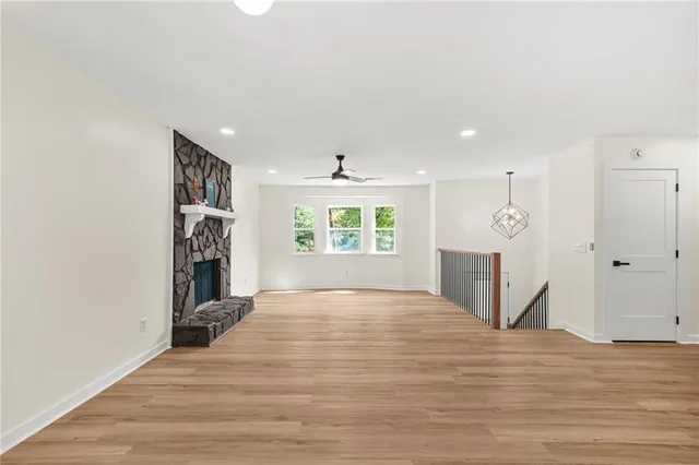 a view of an empty room with window and wooden floor