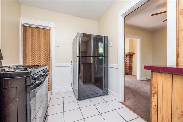 a kitchen with a refrigerator a stove top oven and cabinets