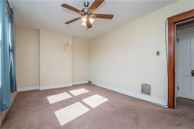 an empty room with closet and a chandelier fan