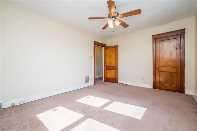 an empty room with closet and a chandelier fan
