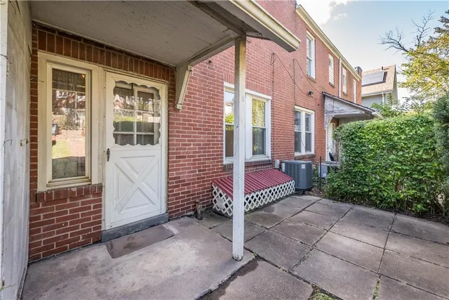 a view of a brick house with a bench in a yard