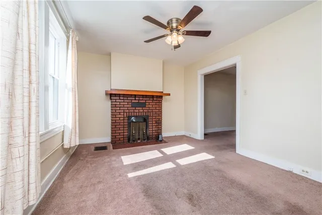 an empty room with windows and a ceiling fan