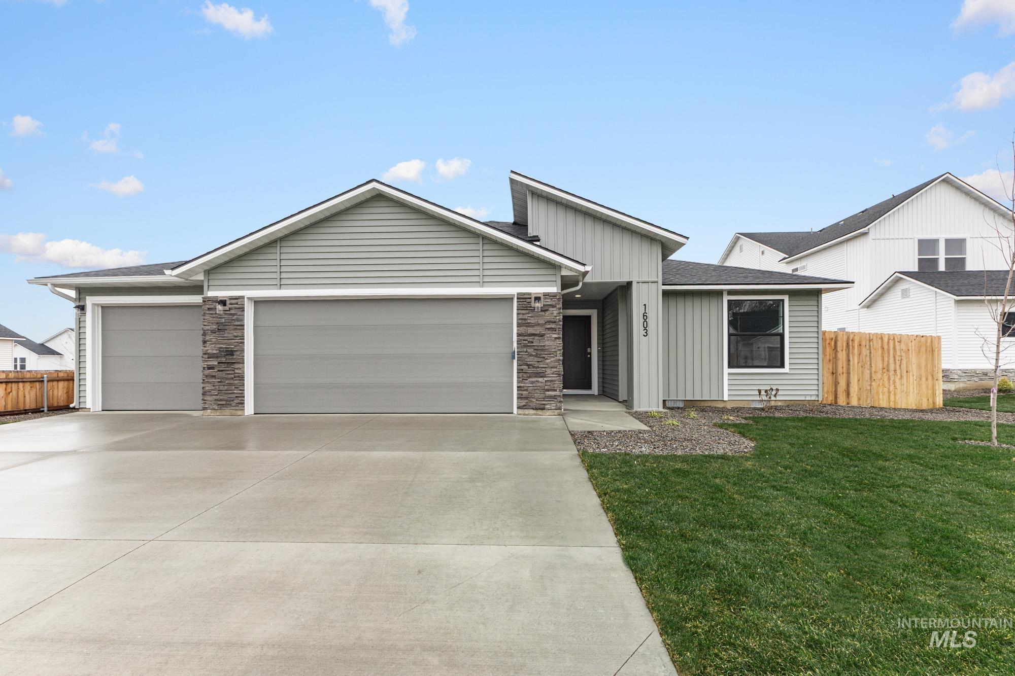 View of front of house with an attached garage, concrete driveway, board and batten siding, and stone siding