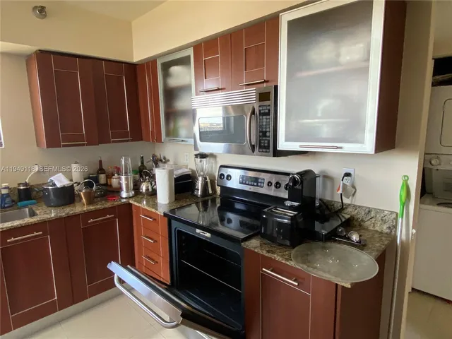 a kitchen with stainless steel appliances granite countertop a refrigerator and a stove