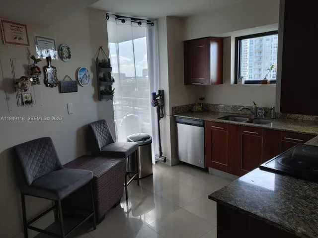 a kitchen with granite countertop a refrigerator and a sink