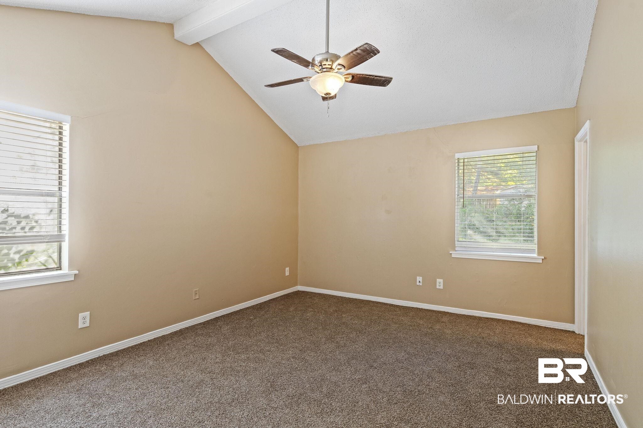 4151 Springdale Road Mobile, AL 36609 - Photo 10 of 21 Carpeted empty room with ceiling fan and vaulted ceiling with beams