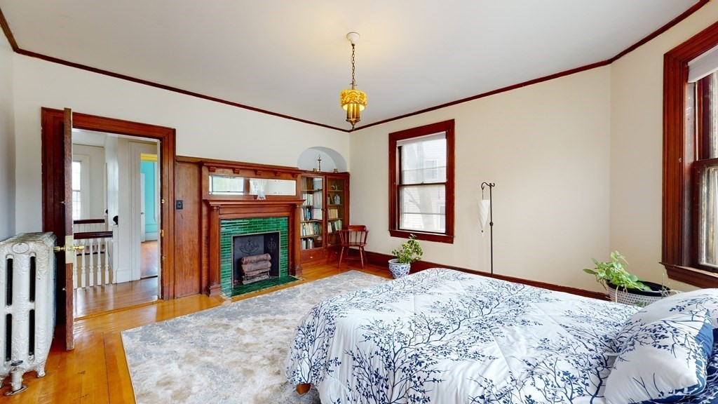 384 Arborway Boston, MA 02130 - Photo 11 of 39 a bedroom with a bed large window and a flat tv screen