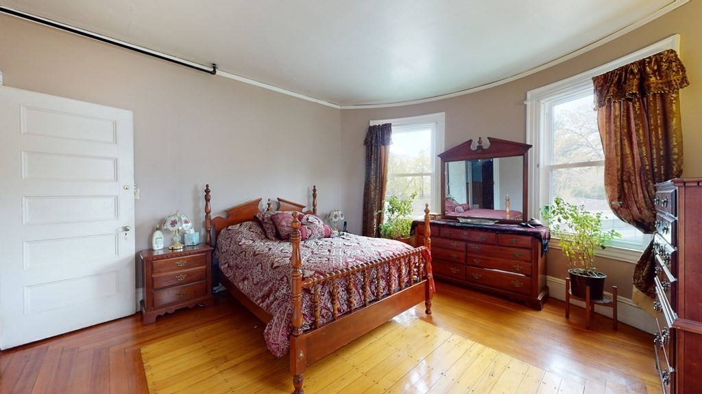 384 Arborway Boston, MA 02130 - Photo 14 of 39 a bedroom with a bed window and a mirror
