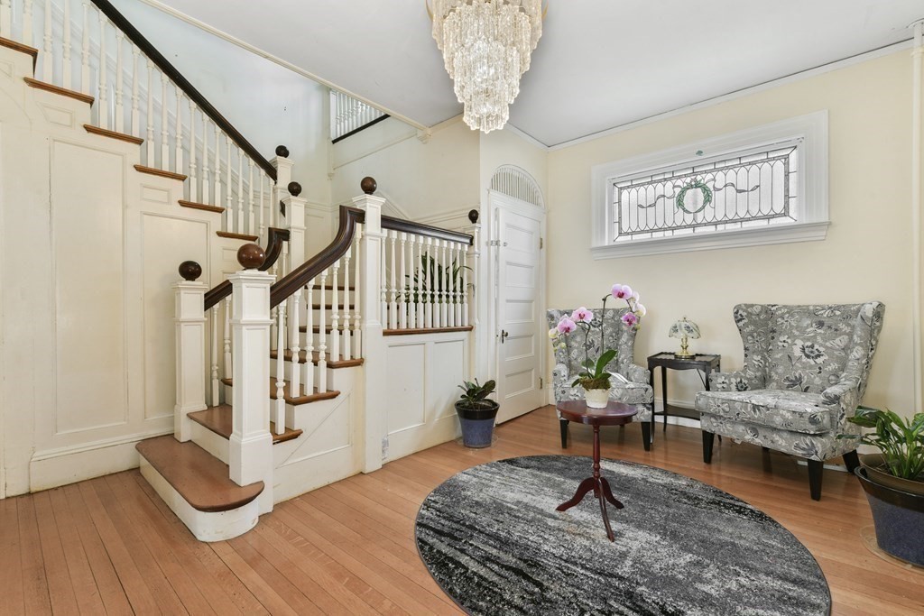 384 Arborway Boston, MA 02130 - Photo 4 of 39 a living room with furniture and a chandelier